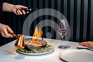 Steak flambÃ© at table in gourmet restaurant