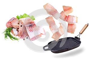 A steak of flying fish falls into the pan. The effect of flying motion in the cooking process.Isolated objects on a white