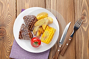 Steak with grilled potato, corn and tomato