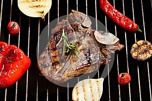 Steak grilled with vegetables. Fried meat on fire, barbecue. Black isolate