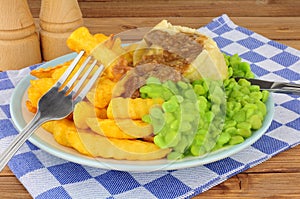 Steak And Kidney Pudding Meal With Chips And Mushy Peas