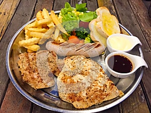 Steak mixed with gravy sauce, there are grilled Chicken , Pork chop with black pepper , grilled Sausage , French fries and Salad