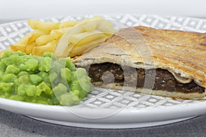 Steak and onion lattice pie with fries and mushy peas.