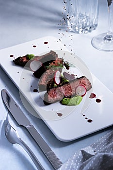 Steak pieces on a dish with peppercorn