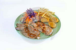 Steak pork chop with nugget, french fries and vegetable salad on dish with white background. Meat steak and french fries serving