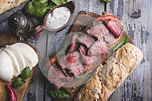 Steak sandwich, sliced roast beef, cheese,spinach leaves,tomato