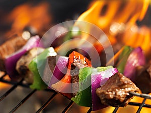 Steak shish kabobs on grill with flames photo