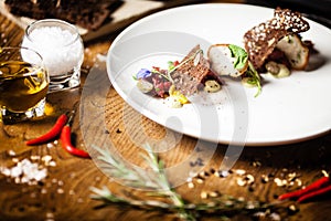 Steak tartare: Horseradish creme, black bread and baguette chips on a plate. Delicious healthy food closeup served for