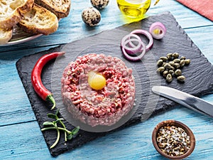 Steak tartare served with raw quail egg yolk, capers and bread. Meat dish