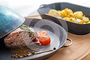 Steak with tomatoes and baked potatoes, dinner food, restaurant
