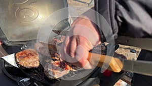 Steaks being cooked on the grill, close-up. A man cooks meat on a gas grill. Cooking outdoors, picnic