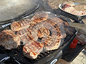 Steaks being cooked on the grill, close-up. A man cooks meat on a gas grill. Cooking outdoors, picnic