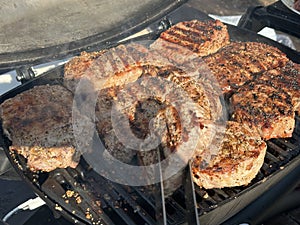 Steaks being cooked on the grill, close-up. A man cooks meat on a gas grill. Cooking outdoors, picnic