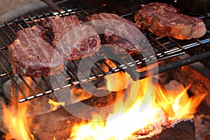 Steaks cooking over a campfire photo