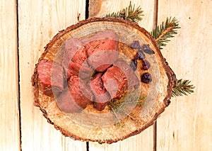 Steaks, pieces of red meat, top view. Raw game meat, beef on wood slice, boards. High quality roe, deer meat. photo