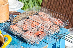 Steaks of red fish - pickled coho salmon in a barbecue grill on a table prepared at the cottage for May weekends for the whole