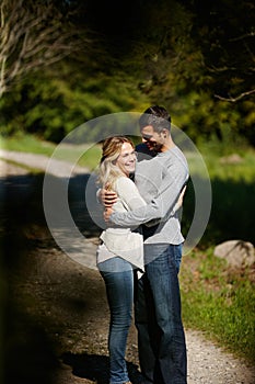 Stealing romantic moment in the park. an affectionate young couple hugging in a park.