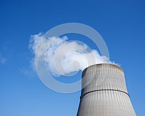 Steam and blue sky above large chimney of nuclear power plant near lingen in lower saxony