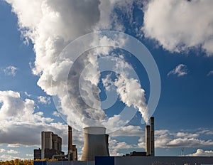 Steam clouds from cooling towers and smoke from chimneys of a brown coal power plant