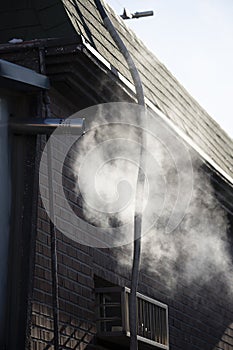 Steam coming out of a central heating flue on a house wall in South Korea