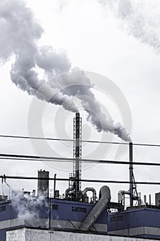 Steam coming out of the chimneys of a paper factory facility in Spain. Air pollution concept