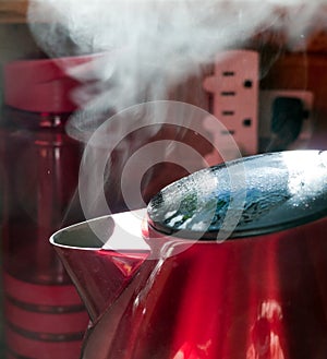 Steam coming out of red metal kettle