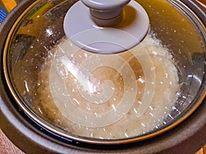 The steam from electric rice cooker in the kitchen.Selective focus food concept