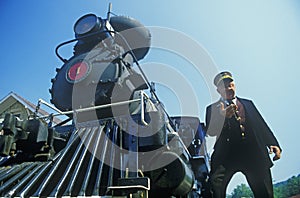 A steam engine conductor checks the time as he stands near the cowcatcher on the front, Eureka Springs, Arkansas