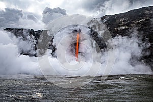 Steam erupts from cold ocean as hot lava pours into water