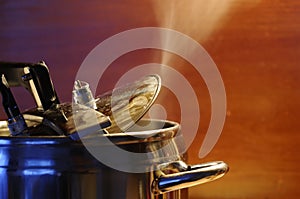 Steam escaping from lid of pressure cooker with reflection of modern kitchen. photo