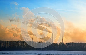 Steam from the factory at sunrise in winter .