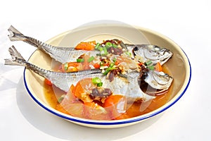 Steam fish in soy sauce with tomato isolated on white