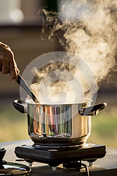 Steam flowing from cooking pot against beautiful morning light