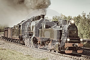 Steam freight train departs from the railway station.