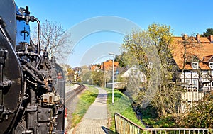 Steam locomotive between inhabited houses in the old town of Wernigerode. Dynamic through motion blur