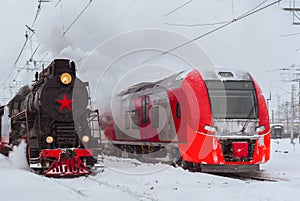 Steam locomotive and modern multiple-unit train stand nearby at station