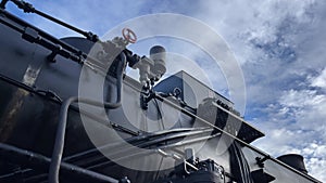 Steam locomotive prepares to leave train station. Mechanisms of engine train