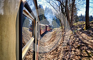 Steam locomotive with railway wagons on the slope in the mountains. Dynamics through motion blur