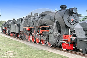 Steam locomotive with red wheels. Retro locomotive on rails. Black locomotive.