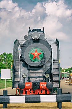 Steam locomotive with red wheels. Retro locomotive on rails. Black locomotive.