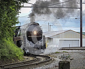 A Steam Locomotive Rounding a Curve Blowing Black Smoke and White Steam