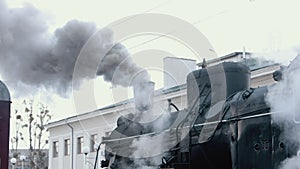 Steam locomotive train approaching station passing through goods yard