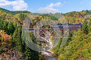 Steam locomotive train crossing the Takiya bridge on Tadami line.