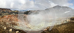 Steam rises above the hot springs of geothermal volcanic zone Landmannalaugar, Iceland