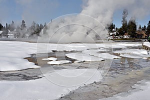 Steam rises from geysers in Yellowstone National Park during winter season.