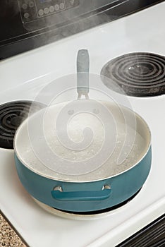 Steam Rising From Boiling Water In Pan On Stove Vertical