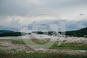 Steam rising from Old Faithful geyser under an overcast sky at dusk in Yellowstone National Park