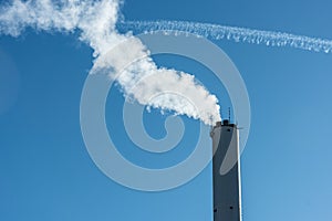 Steam rising from a tall chimney..