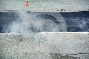 Steam is rising up above the fresh asphalt.