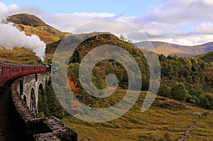 Steam train crossing Glenfinnan Viaduct, Scotland photo